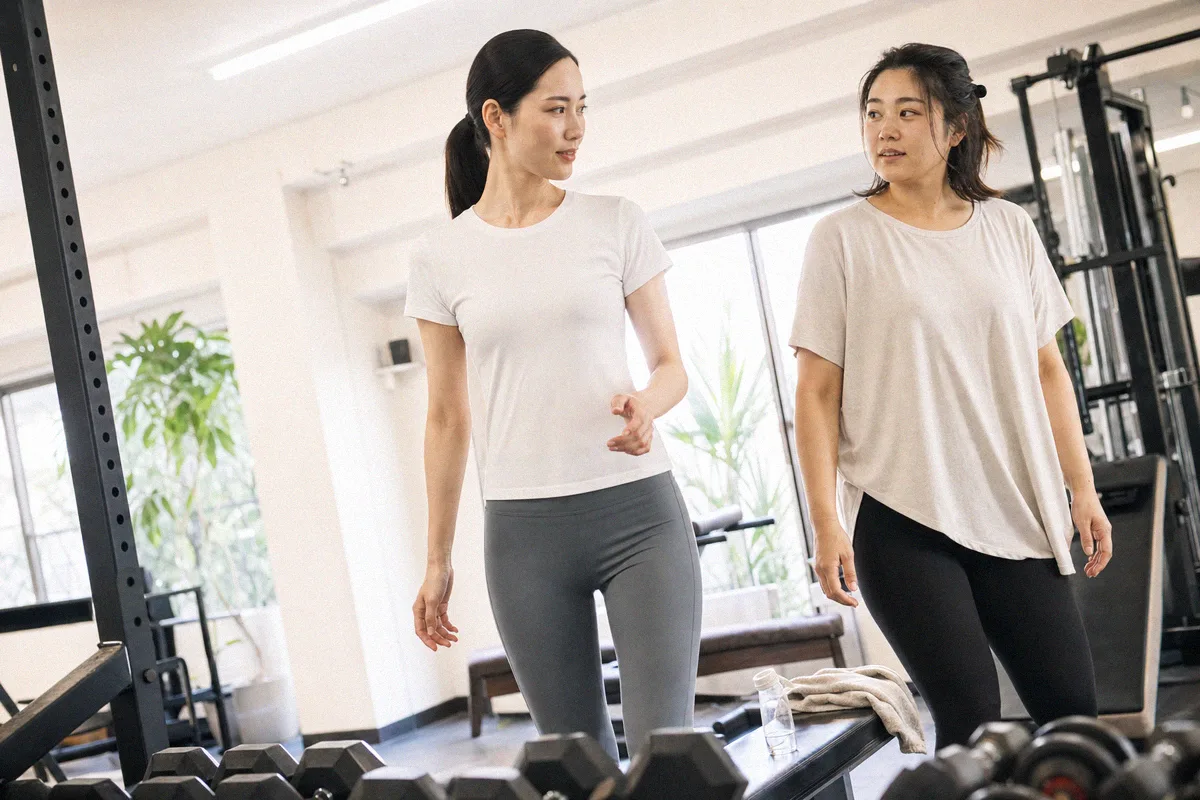 トレーニングの合間にフロアで向き合って話す2人