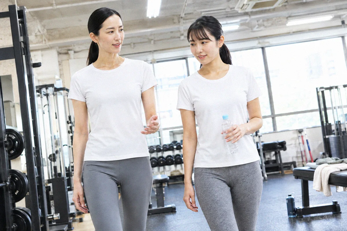 種目の合間にフロアを並んで歩くトレーナーと利用者