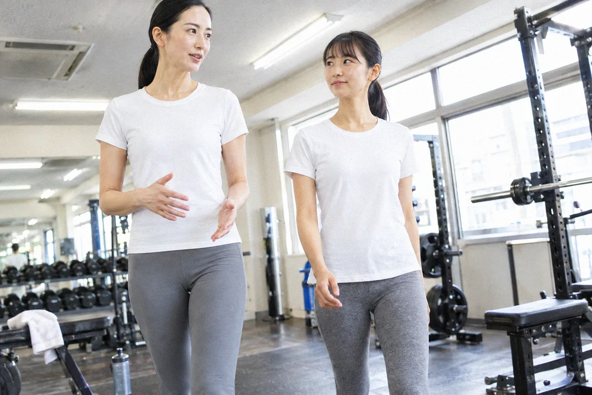 種目の合間にフロアを並んで歩くトレーナーと利用者