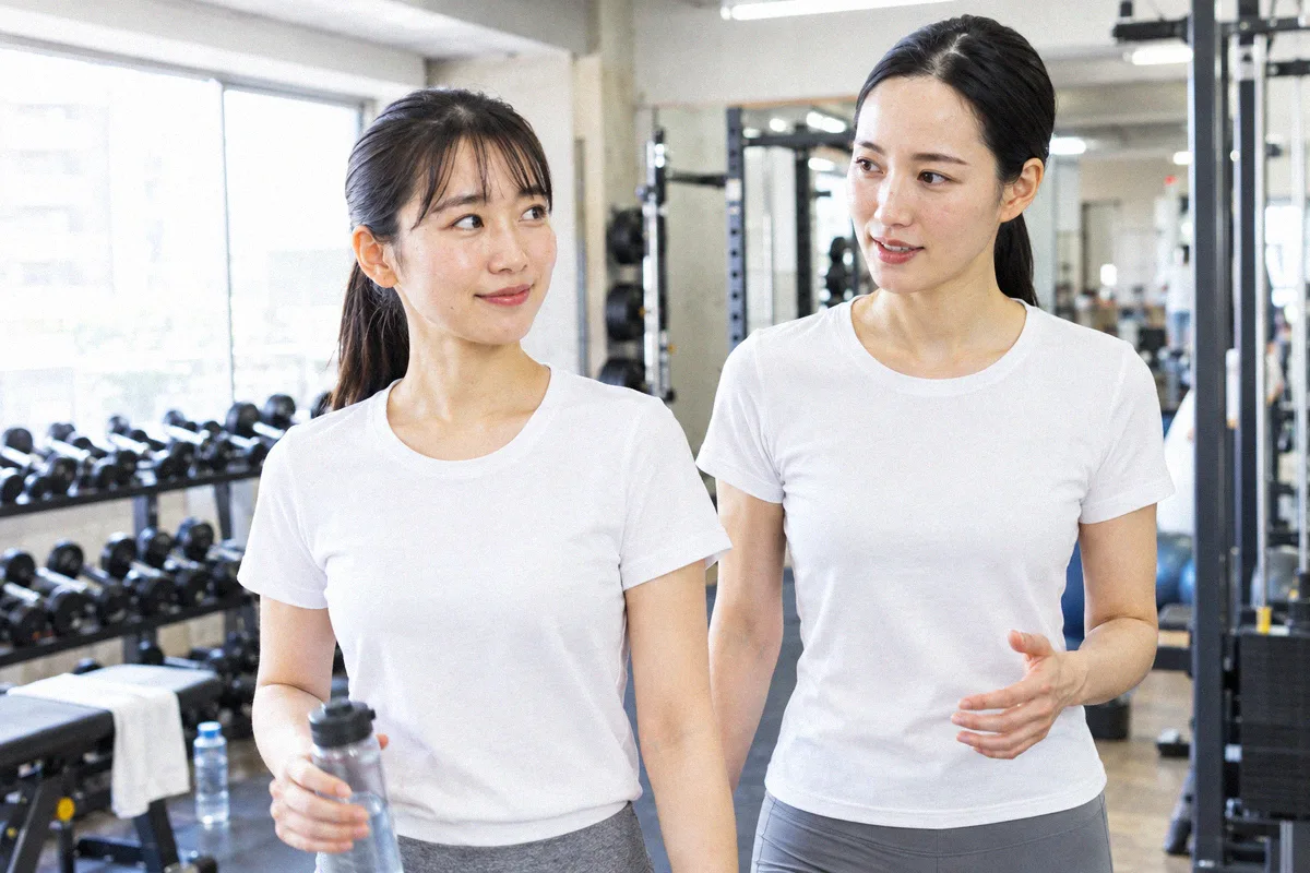 種目の合間にフロアを並んで歩くトレーナーと利用者