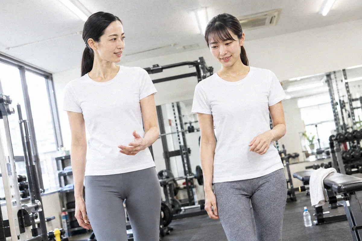 種目の合間にフロアを並んで歩くトレーナーと利用者