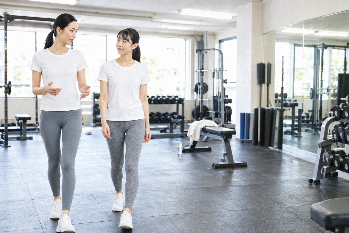 種目の合間にフロアを並んで歩くトレーナーと利用者
