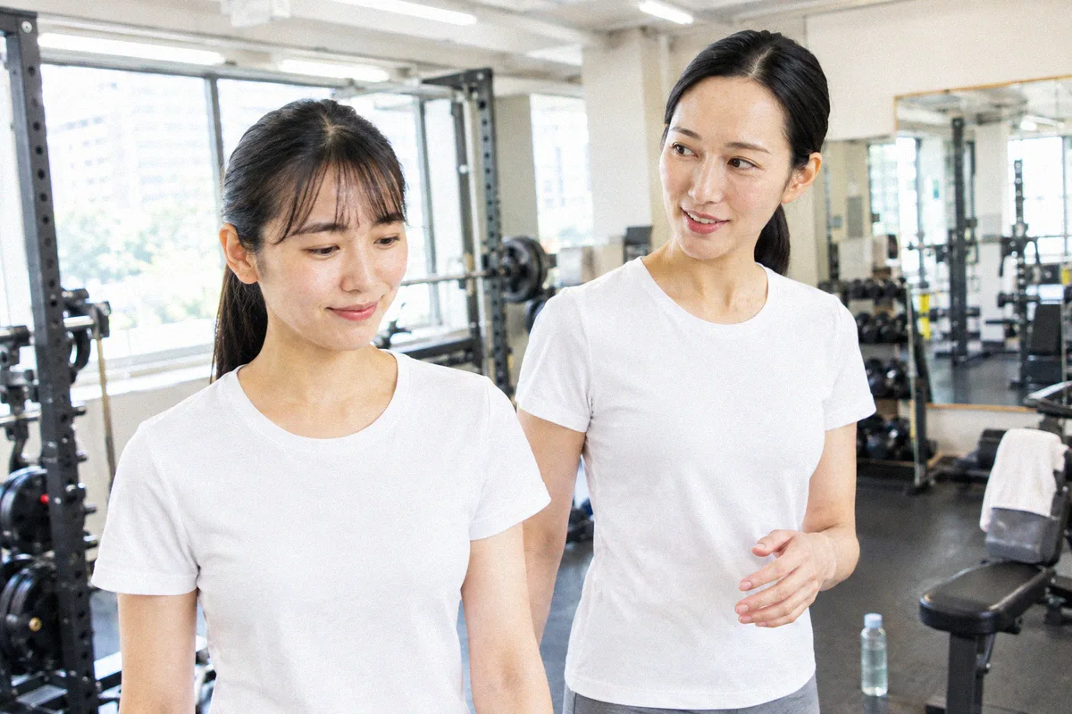 種目の合間にフロアを並んで歩くトレーナーと利用者